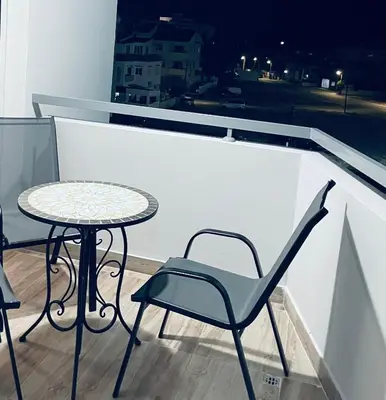 a table and chairs on a balcony with a window at Cyprus Penelope in Larnaka