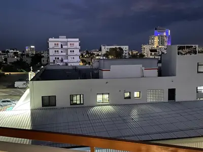 a white building with windows on the roof at night at Cyprus Penelope in Larnaka