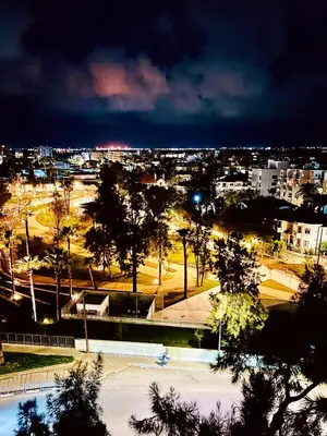 a view of a city at night with lights at Lina 703 in Larnaka