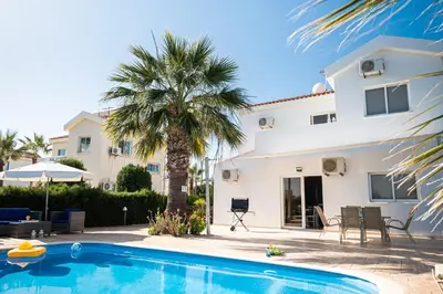 a villa with a swimming pool in front of a house at Protaras View Villas in Protaras
