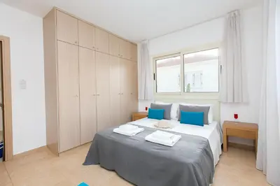 a bedroom with a large bed with blue pillows at Pernera Holiday Villa 588 in Paralimni