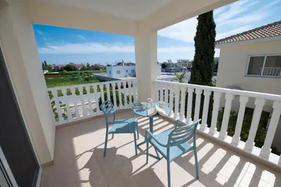 a patio with two chairs and a table on a balcony at Villa Helena in Ayia Napa