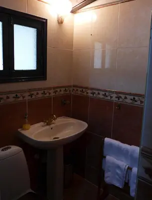 a bathroom with a sink and a toilet and a window at Kalimera A Lovely 1-bedroom rental with ensuite and Kitchen in Limassol
