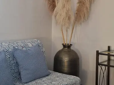 a vase sitting next to a chair with a pillow at Kalimera A Lovely 1-bedroom rental with ensuite and Kitchen in Limassol