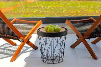 a basket filled with green apples sitting next to two chairs at Protaras Almaria Villa 16 in Protaras