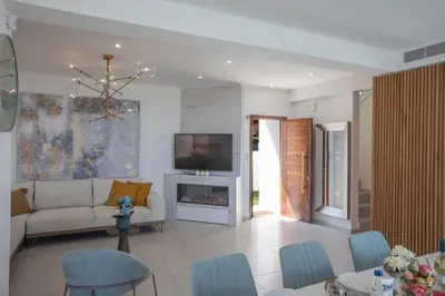 a living room with a couch and a tv at Artizan Seafront Villa 5 in Protaras