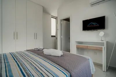 a bedroom with a bed and a tv on the wall at SunnyVillas 4BR New Villa Private Pool in Pernera in Protaras