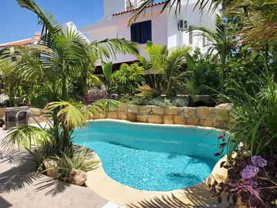 a swimming pool in front of a house at Villa - Sleeps 6 free parking & heated pool in Protaras