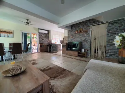 a living room with a tv and a brick wall at Villa - Sleeps 6 free parking & heated pool in Protaras
