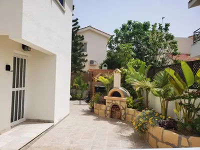 a courtyard with a stone wall and a pizza oven at Villa - Sleeps 6 free parking & heated pool in Protaras
