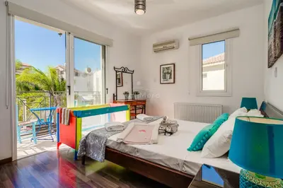 a bedroom with a large bed and large windows at Villa Emily in Protaras