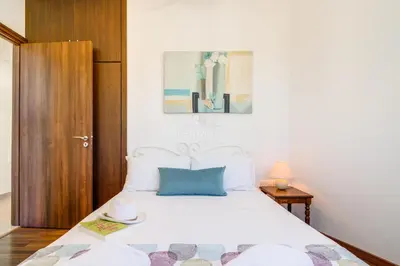 a bedroom with a white bed with a blue pillow at Villa Emily in Protaras