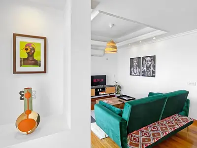 a living room with a green couch and a guitar at 180° SEAVIEW Apt. right on famous beach promenade in Larnaka