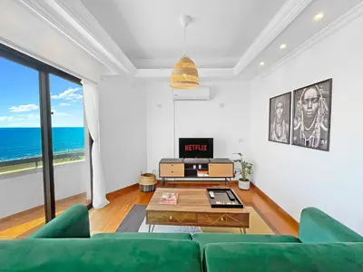 a living room with a green couch and a table at 180° SEAVIEW Apt. right on famous beach promenade in Larnaka