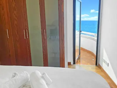 a bedroom with a bed with a view of the ocean at 180° SEAVIEW Apt. right on famous beach promenade in Larnaka