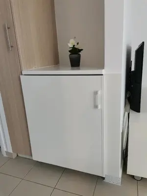 a white cabinet with a plant on top of it at City Flats 308 in Larnaka