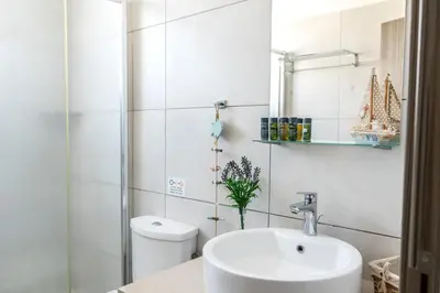 a white bathroom with a sink and a toilet at Ayia Thekla Seafront Villa Dagi in Ayia Napa