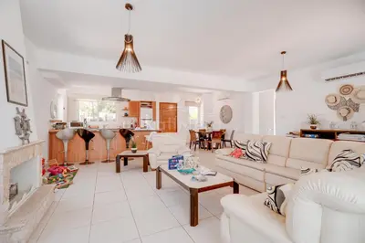 a living room with white couches and a kitchen at Villa Hanna in Protaras
