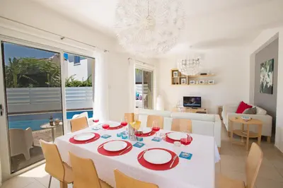 a dining room and living room with a table and chairs at Kalamies Family Villa in Protaras