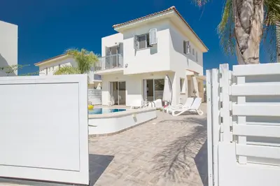 a white fence in front of a house at Kalamies Family Villa in Protaras