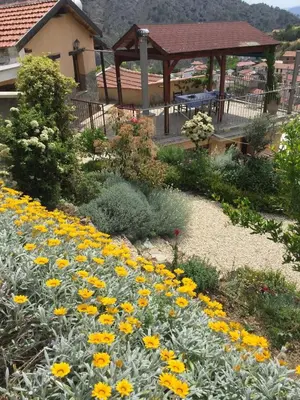 a garden with yellow flowers and a gazebo at Rodous Village House in Limassol