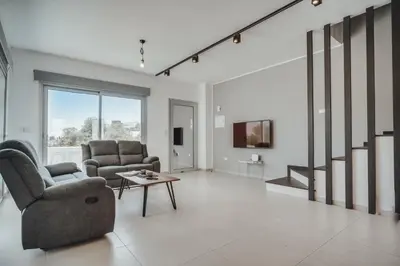 a living room with two chairs and a table at Stay in Style in Modern 3 Bedroom Villas Near Nissi Beach & Square in Ayia Napa