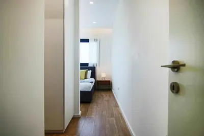 a hallway leading to a bedroom with a bed and a door at Phaedrus Living: City View Anna Residence 101 in Limassol