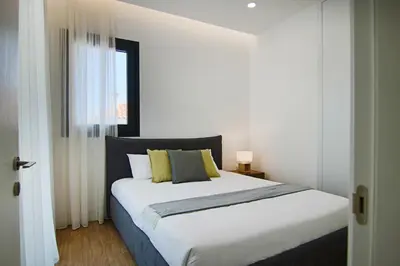 a bedroom with a large white bed with yellow pillows at Phaedrus Living: City View Anna Residence 102 in Limassol