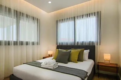 a bedroom with a large bed with two windows at Phaedrus Living: Sea View Anna Residence 201 in Limassol