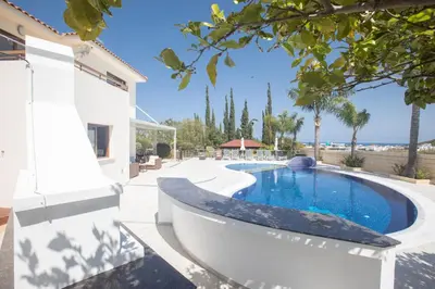 a swimming pool with a bath tub next to a house at Villa Margarita in Protaras
