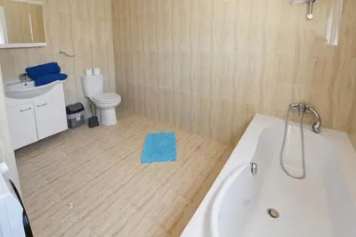 a bathroom with a tub and a toilet and a sink at Nissi Villa Sotia in Ayia Napa