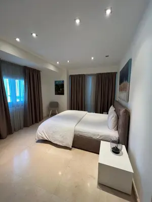 a bedroom with a large bed and a table at Aphrodite Plaza in Larnaka