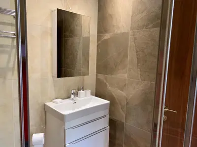 a bathroom with a sink and a mirror and a shower at STUDIO in CAPTAINS HOUSE WITH A POOL in Limassol