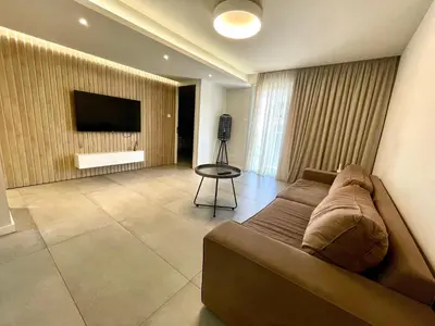 a living room with a couch and a flat screen tv at Central Business Suites Nicosia - Araouzou By Platform 357 in Nicosia