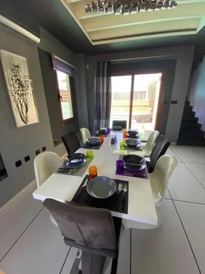 a dining room with a white table and chairs at Purple Villa Protaras - Paralimni in Paralimni