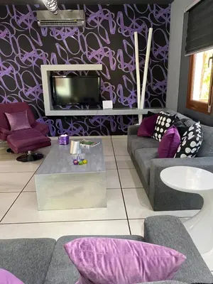 a living room with purple walls and a tv at Purple Villa Protaras - Paralimni in Paralimni