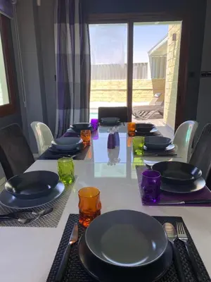 a table with plates and glasses on top of it at Purple Villa Protaras - Paralimni in Paralimni