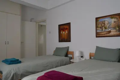 a room with two beds and a mirror at MAMA'S FLAT - ΤΟ ΔΙΑΜΕΡΙΣΜΑ ΤΗΣ ΜΑΜΑΣ in Strovolos