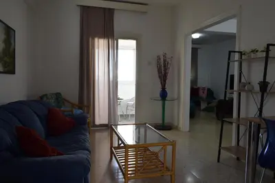 a living room with a blue couch and a glass table at MAMA'S FLAT - ΤΟ ΔΙΑΜΕΡΙΣΜΑ ΤΗΣ ΜΑΜΑΣ in Strovolos
