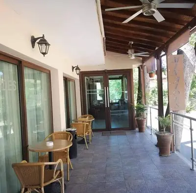 a patio with chairs and tables and a ceiling fan at Minaides Hotel in Kakopetria