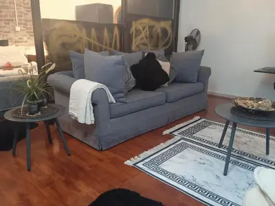 a living room with a couch and two tables at Lovely Cozy Apartment in the entrance of Nicosia in Aglantzia
