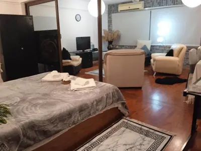 a bedroom with a bed and a living room at Lovely Cozy Apartment in the entrance of Nicosia in Aglantzia