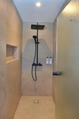 a bathroom with a shower with a light on the wall at Panas Villas in Ayia Napa