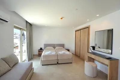 a bedroom with a bed and a tv and a couch at Panas Villas in Ayia Napa