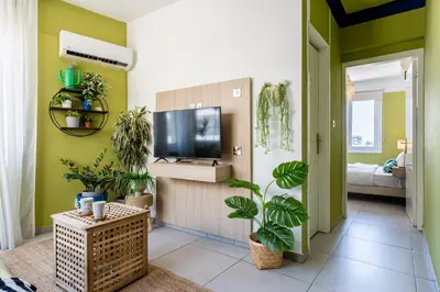 a living room with green walls and potted plants at Whispering Palms 1-BR Apt By Finikoudes Beach in Larnaka