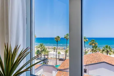 a view of the beach from a hotel room at Whispering Palms 1-BR Apt By Finikoudes Beach in Larnaka