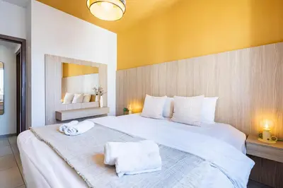 a bedroom with a large white bed with towels on it at Made with love 1-BR Apt By Finikoudes Beach in Larnaka