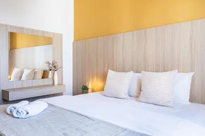 a bedroom with a large white bed with a large mirror at Made with love 1-BR Apt By Finikoudes Beach in Larnaka