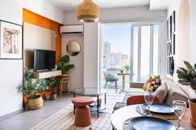 a living room with a couch and tables and a tv at Made with love 1-BR Apt By Finikoudes Beach in Larnaka