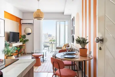 a kitchen and living room with a table and chairs at Made with love 1-BR Apt By Finikoudes Beach in Larnaka